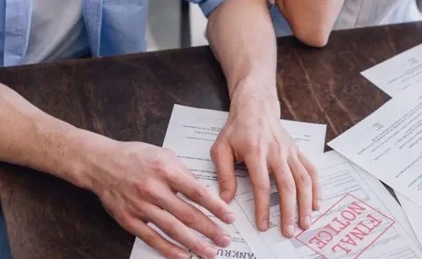 des mains posées sur des papiers de bureau